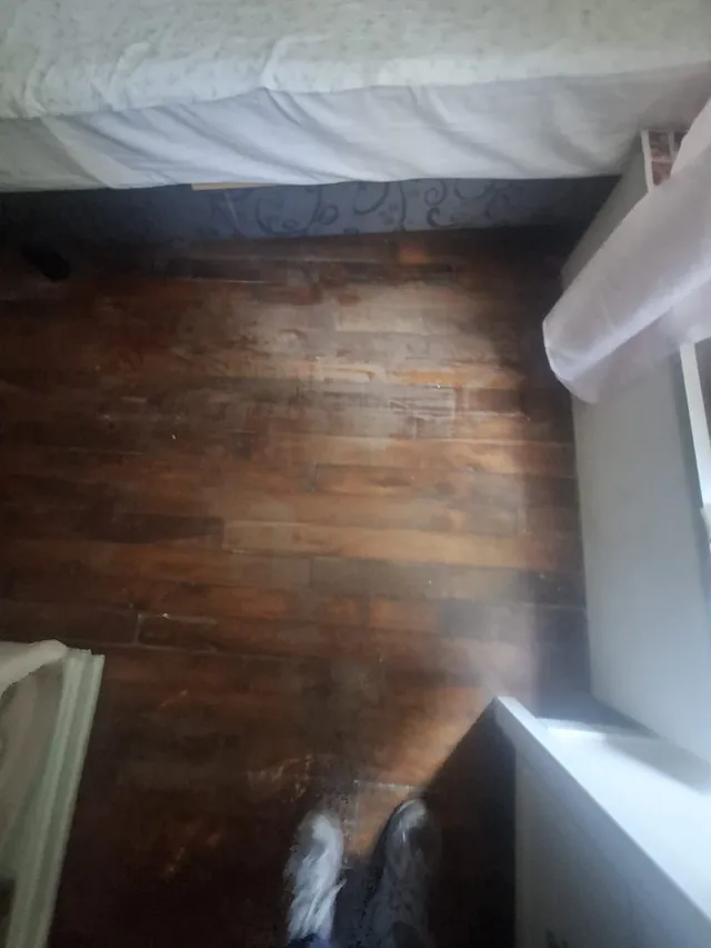 Pièce entièrement vidée, parquet dégagé après intervention